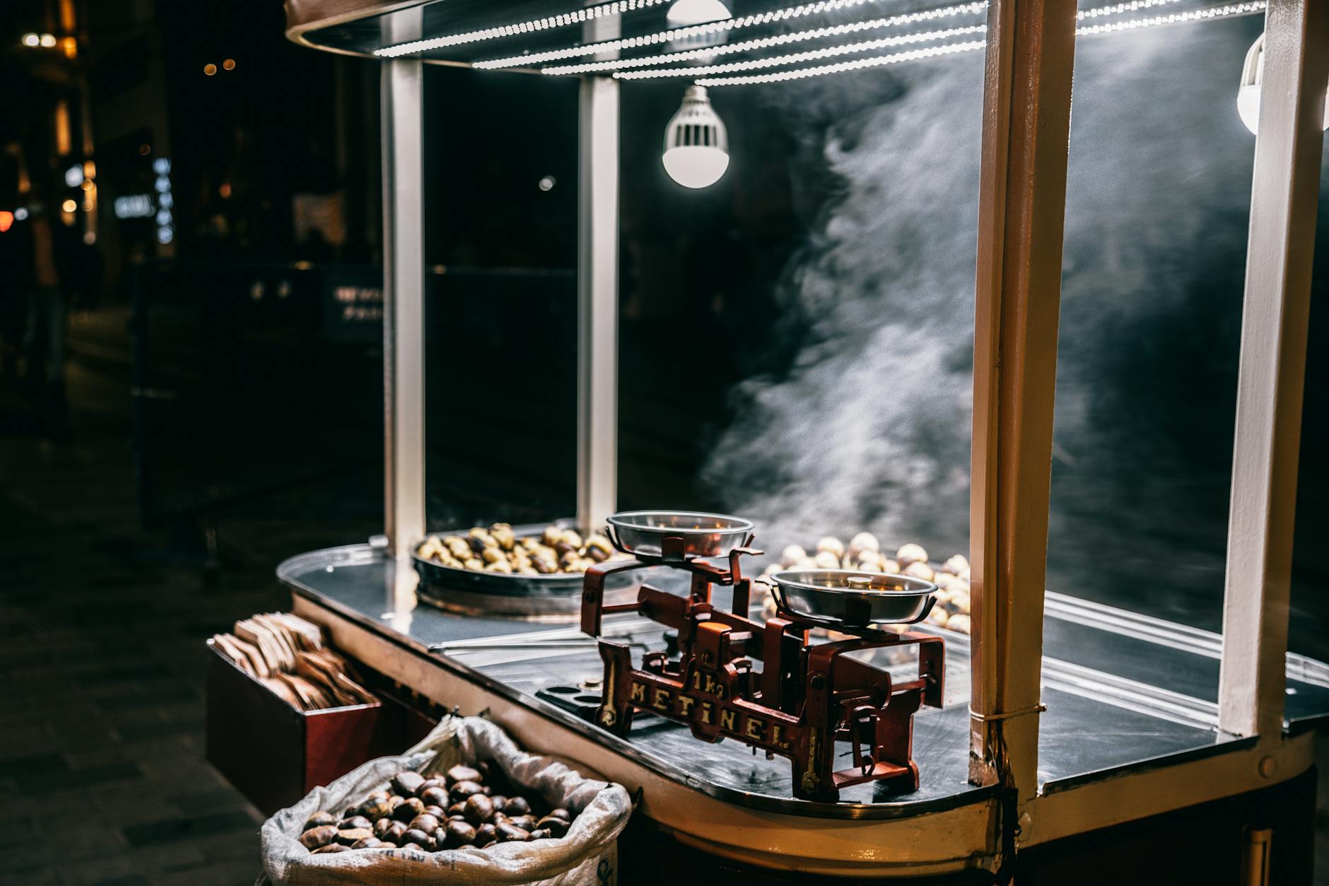 Discover the aroma of roasted chestnuts at a bustling Istanbul street food stall by night.