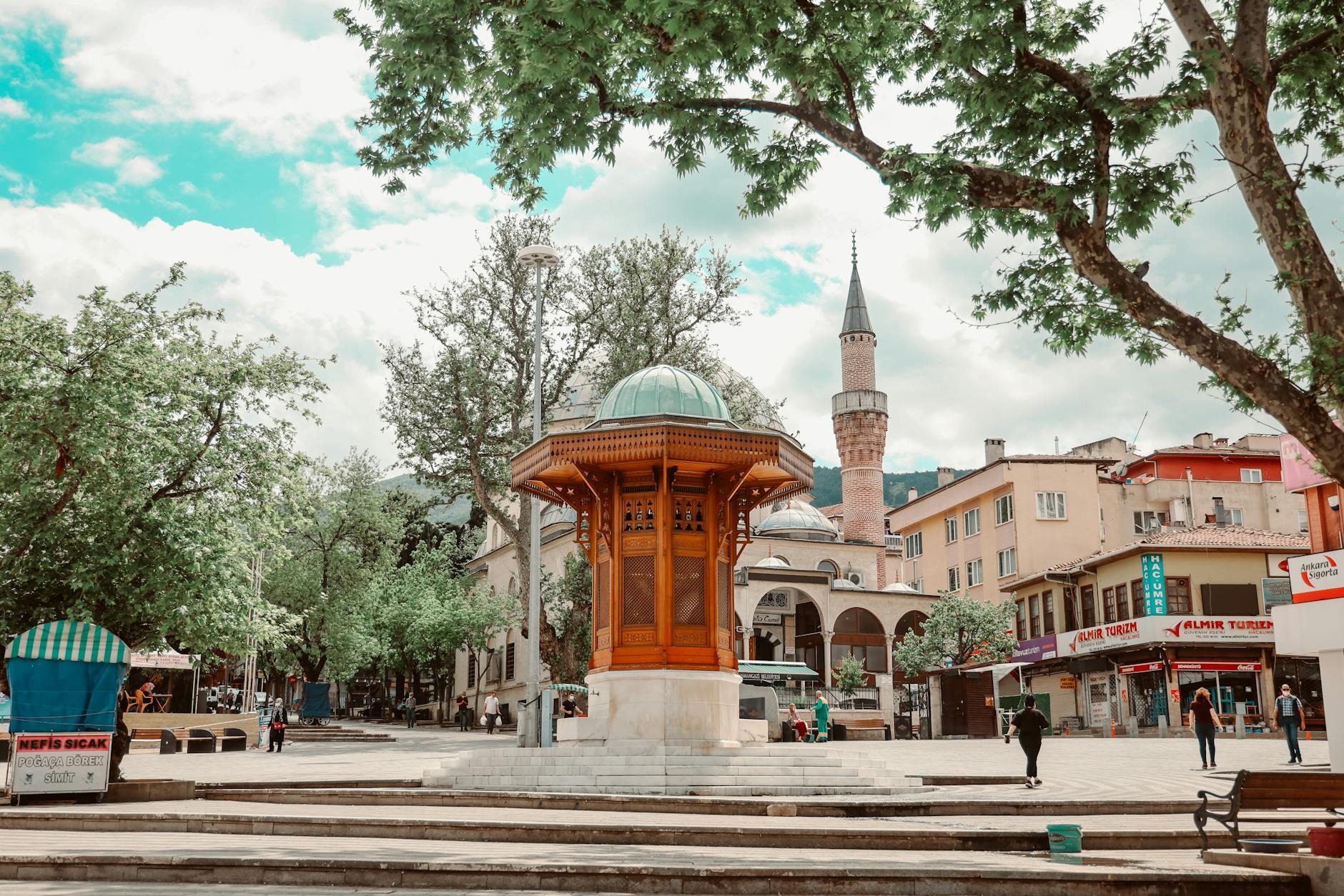 Charming town square with traditional architecture and mosque in a lively urban setting.