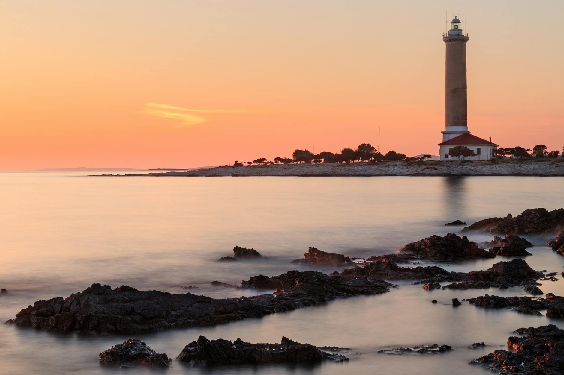 Capture the tranquil beauty of Veli Rat Lighthouse at sunset on the Croatian coast.