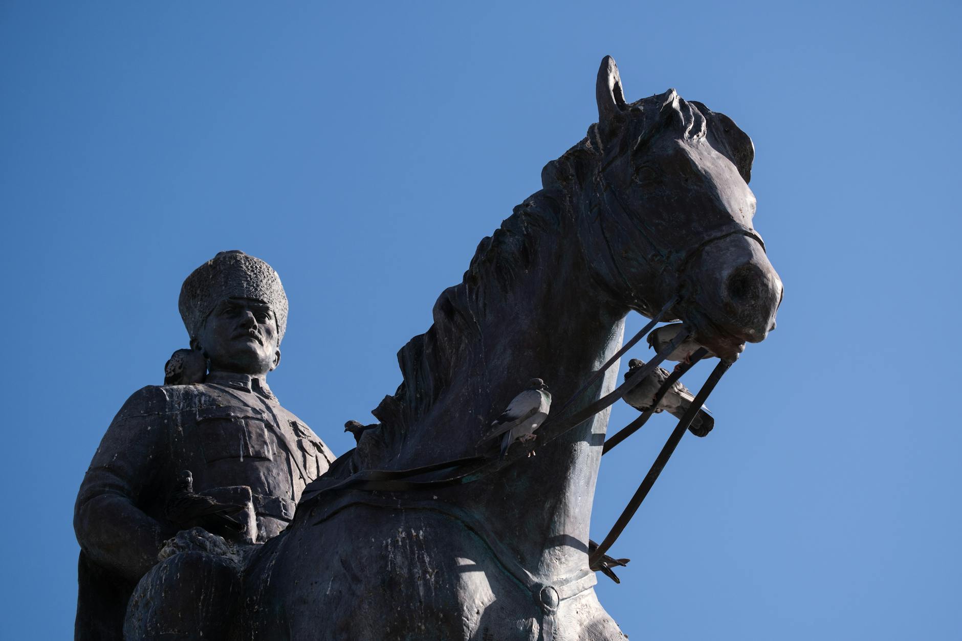 Statue of Mustafa Kemal Atatürk on horseback against a clear blue sky in İzmir, Turkey.